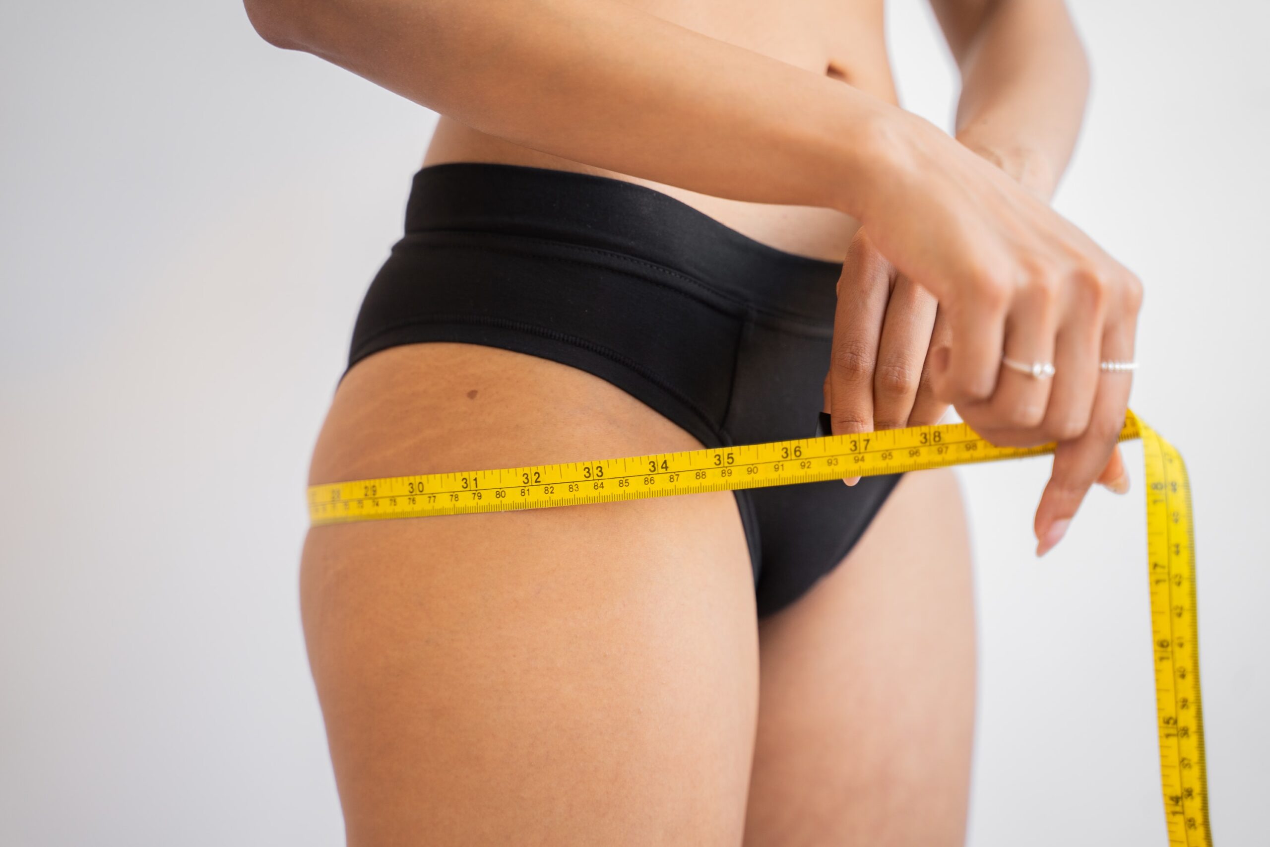 woman measuring bottom to reduce cellulite